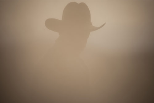 cowboy in dust cloud